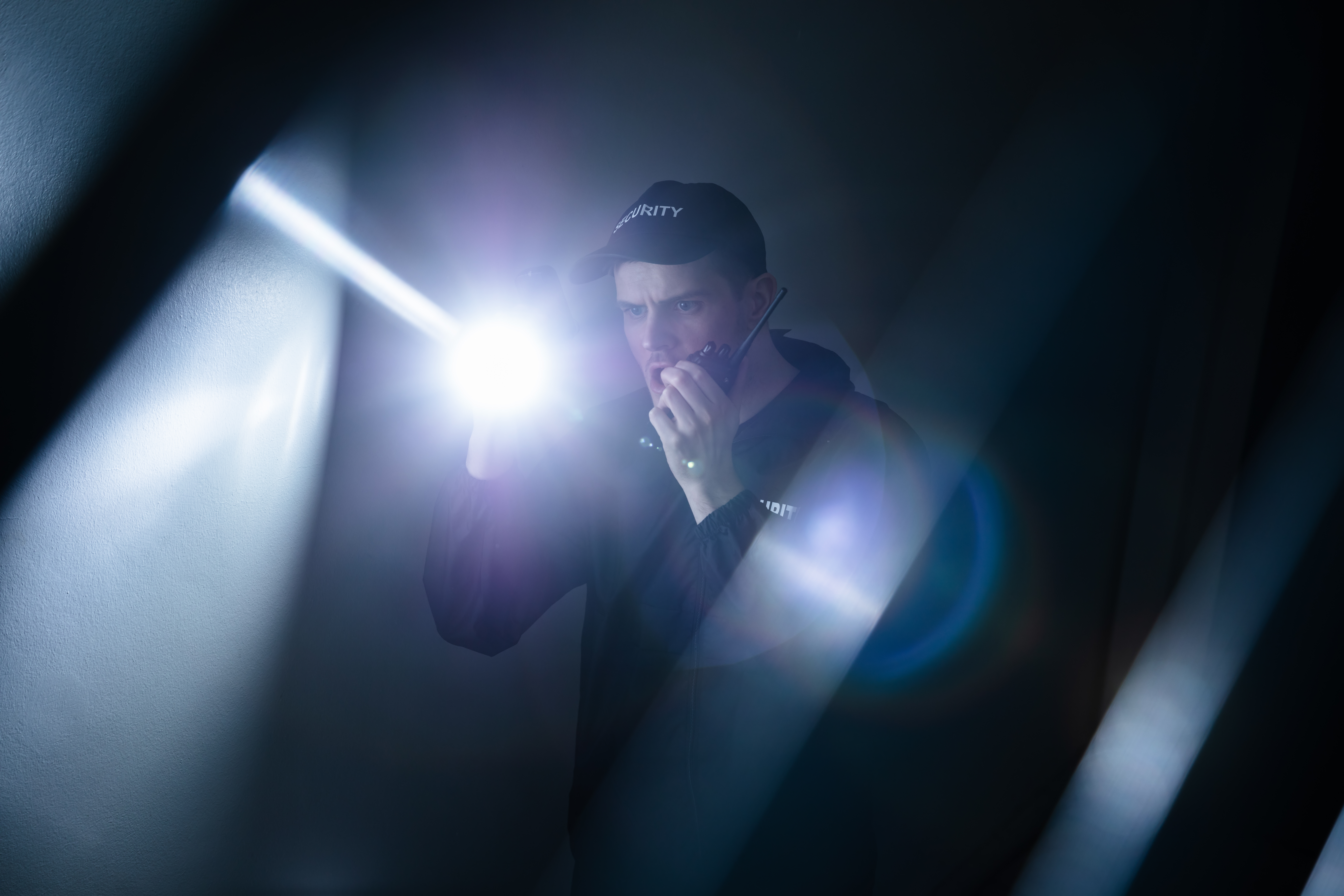 Male,Security,Guard,In,Black,Uniform,Using,Walkie-talkie,And,Flashlight